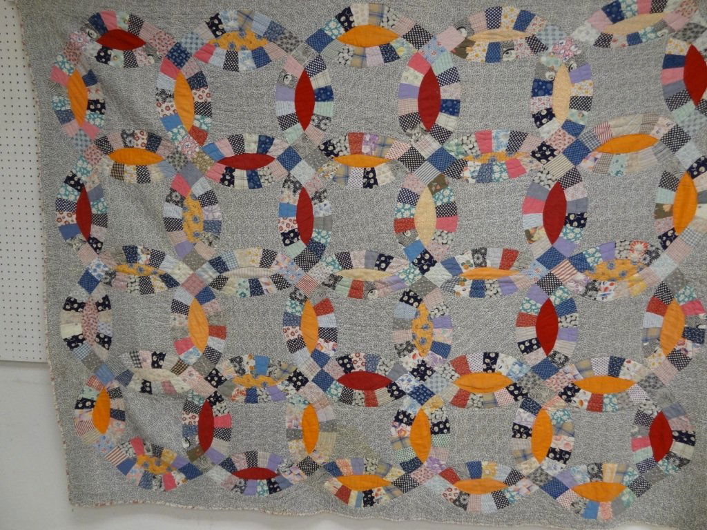 DOUBLE WEDDING RING QUILT, 1930'S FABRIC, HAND PIECED A: DOUBLE WEDDING RING QUILT, 1930'S FABRIC, HAND PIECED AND QUILTED, BACKED WITH FLANNEL, 84 1/2'' X 67 1/2'', SOME STAINS.