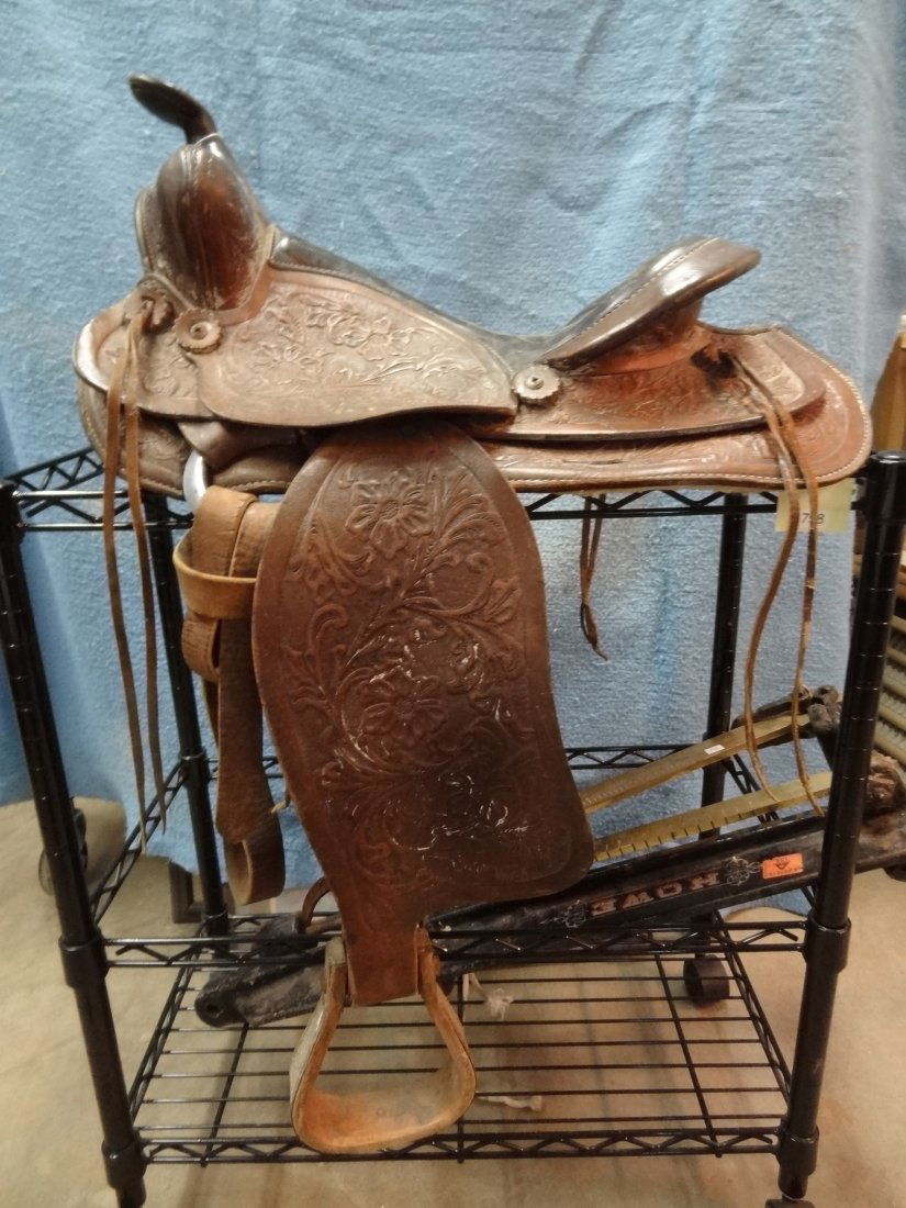 OLD 16'' WESTERN LEATHER HIGHLY TOOLED SADDLE, MEASUREM: OLD 16'' WESTERN LEATHER HIGHLY TOOLED SADDLE, MEASUREMENTS: SEAT 16'', SKIRT 22'' HORN 3'', STIRRUPS 23''-34'', MANUFACTURER MARK LOCATED ON FENDER, THE ONLY MARKING IDENTIFIABLE 7400. SEE 'SHIPPING