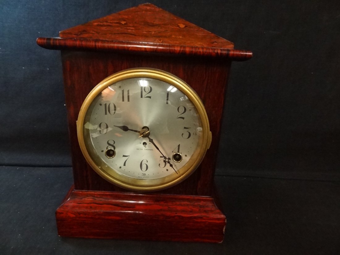 SETH THOMAS MANTLE CLOCK, BRASS RIM METAL FACE, WOOD VE: SETH THOMAS MANTLE CLOCK, BRASS RIM METAL FACE, WOOD VENEER GRAIN, MEASURES 11 1/2 X 8 1/2 X 5 1/2, SOME CHIPS TO THE VENEER. TAHSAC IS NOT EQUIPPED TO SHIP THIS ITEM. PLEASE CALL FOR LOCAL SHIPPING C