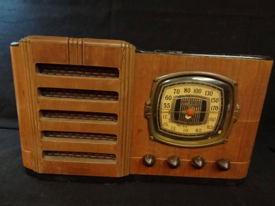AIR CHIEF TUBE RADIO MODEL 85275, WOOD CASE WITH CELLUL: AIR CHIEF TUBE RADIO MODEL 85275, WOOD CASE WITH CELLULOID KNOBS, MARKED AMERICAN KILOCYCLES AND FOREIGN MEGACYCLES, CASE HAS A CRACK ON RIGHT TOP CORNER OF SPEAKER. UNIT POWERS UP. MEASURES 18'' X 10