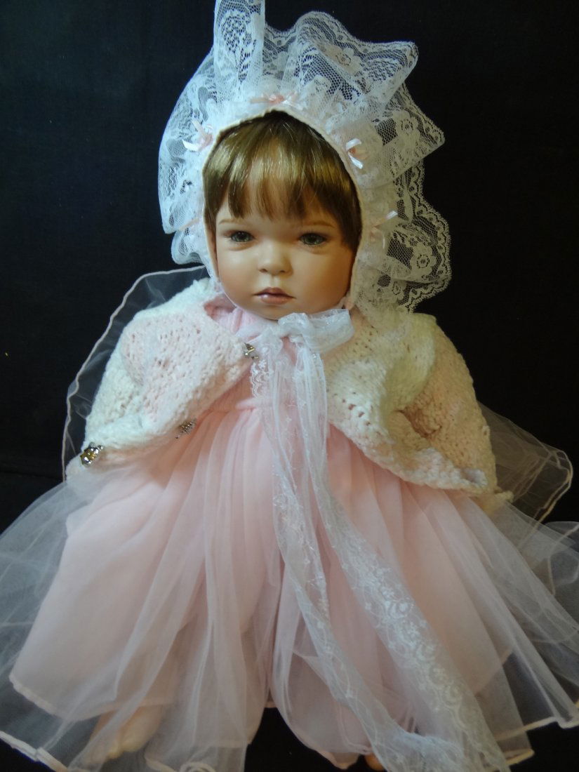 GLORIA VANDERBILT DOLL WITH BISQUE HEAD AND LIMBS, SOFT: GLORIA VANDERBILT DOLL WITH BISQUE HEAD AND LIMBS, SOFT BODY, BROWN HAIR, GREEN GLASS EYES, ROSY CHEEKS AND MOUTH, SIGNED AND NUMBERED 0719/5000, CIRCA 2000, 19'' LONG IN A SITTING POSITION, WEARING F