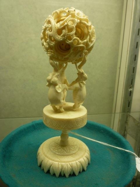 IVORY WEDDING BALL ON ELEPHANT PEDESTAL: ASIAN STYLE,: ASIAN STYLE, AMAZING INTRICACY. THE BALL IS MADE TO SIT ON THE TUSKS OF THE ELEPHANTS, BUT ONE TUSK IS BROKEN SO MUST BE CAREFUL. BALLS INSIDE OF THE LARGER BALL ARE LOOSE AND MOVE. DRAGONS ON THE OUT