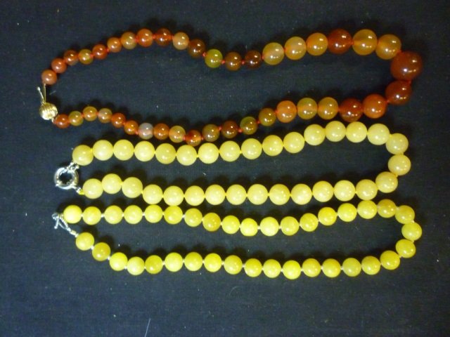 AMBER LIKE AND 2 JADE LIKE NECKLACES: AMBER COLORED NEC: AMBER COLORED NECKLACE HAS 14K GOLD HOOK AND IS APPROX. 18" LONG. OTHERS ARE 15" AND 16"