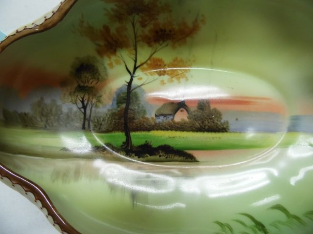 NIPPON CANDY DISH HAND PAINTED CANDY DISH, INSIDE OF DI: HAND PAINTED CANDY DISH, INSIDE OF DISH DEPICTS A SMALL HOME AND COUNTRYSIDE, BOTTOM MARKED " HANDPAINTED NIPPON", APPROX 7.5" LONG BY 4.5" WIDE.