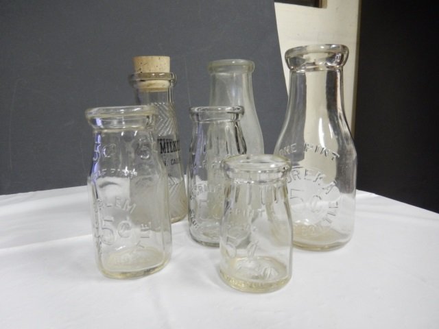 ANTIQUE MILK BOTTLES LOT INCLUDES 6 ANTIQUE CLEAR GLASS: LOT INCLUDES 6 ANTIQUE CLEAR GLASS MILK BOTTLES. ONE BOTTLE IS CRACKED (SEE PIC) BUT ALL OTHER BOTTLES ARE IN EXCELLENT CONDITION AND RANGE IN HEIGHT FROM 4" TO 7.5".