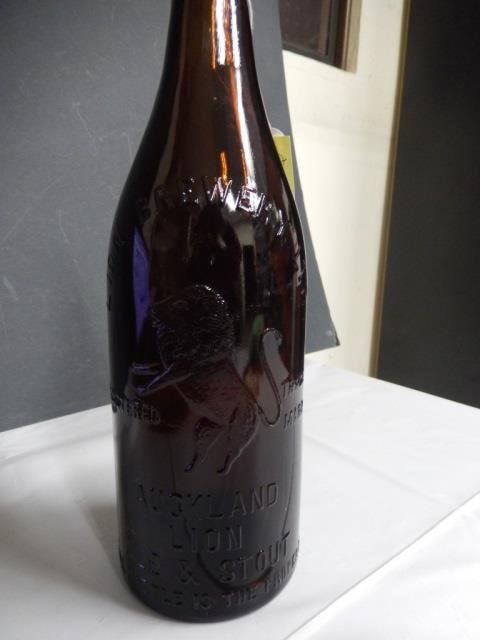 AUCKLAND LION ANTIQUE BEER BOTTLE ANTIQUE AMBER BEER: ANTIQUE AMBER BEER BOTTLE MONOGRAMMED "LION BREWERY, LTD. RSTRICTED TRADE MARK. AUCKLAND LION ALE & STOUT. THIS BOTTLE IS THE PROPERTY OF THE LION BREWERY LTD." BOTTLE IS APPROX 11.5" TALL AND IS IN E