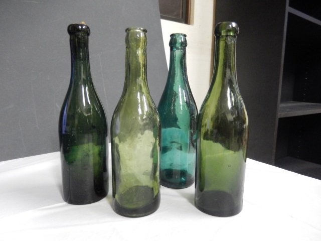 4 ANTIQUE GREEN BEER BOTTLES LOT INCLUDES 4 GREEN: LOT INCLUDES 4 GREEN ANTIQUE BEER BOTTLES. EACH BOTTLE IS APPROX 9.5" TALL AND IN EXCELLENT CONDITION. ONE HAS ORIGINAL CORK.