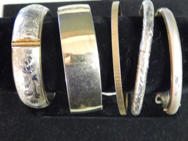 5 GOLD TONE BANGLE BRACELETS LOT INCLUDES 5 GOLD ONE: LOT INCLUDES 5 GOLD ONE BANGLE BRACELETS, 1 MARKED "MONET"