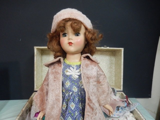 VINTAGE DOLL WITH CASE LOT INCLUDES NICE VINTAGE DOLL: LOT INCLUDES NICE VINTAGE DOLL WITH BLINKING BLUE EYES AND MOVING ARMS. APPROX 17.5' TALL. SHE HAS ORIGINAL HAIR AND IS MARKED "R&B" ON BACK OF NECK. SHE COMES WITH PORTABLE PINK CASE AND ASSORTED CLO