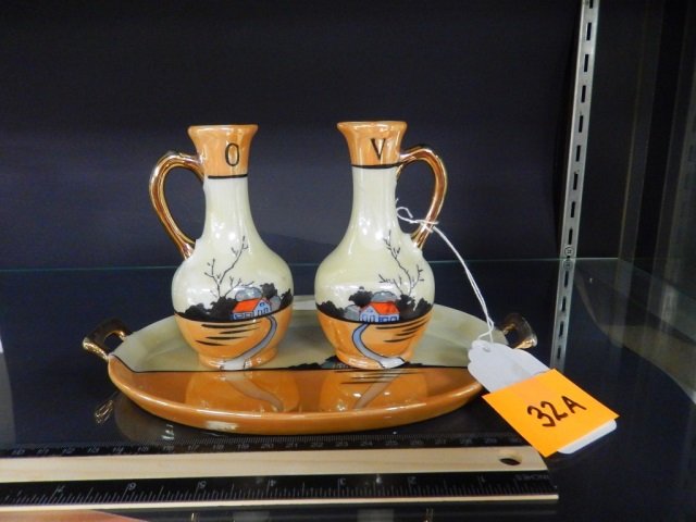 NIPPON VINTAGE OIL & VINEGAR CRUETS: 3 PIECE SET. STAMPED "NIPPON HAND PAINTED MADE IN JAPAN" ON BOTTOM. EACH HAS A SIMILAR HOUSE SCENE PAINTED APPROX 5" TALL, COMES WITH SERVING TRAY APPROX 9" LONG. NO CHIPS OR CRACKS