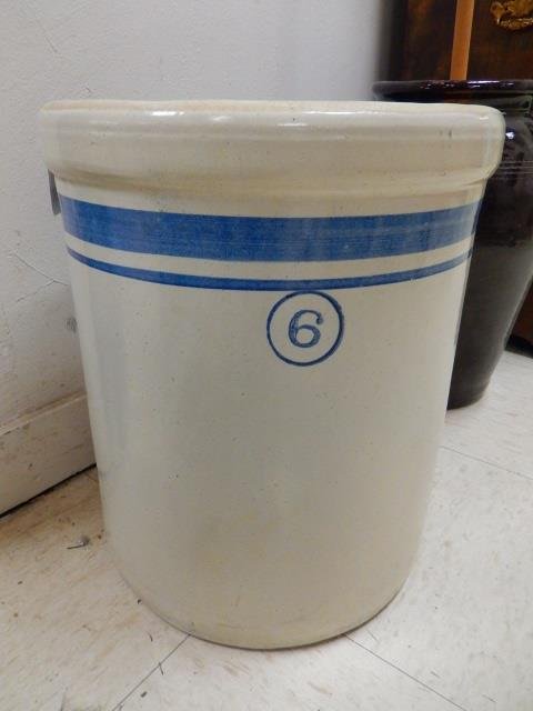 # 6 CROCK: WHITE WITH BLUE STRIP DETAIL AND THE NUMBER "6" ON FRONT. APPROX 15" TALL AND 12.5" DIAMETER. WEIGHS APPROX 40 POUNDS. NO MARK ON BOTTOM. IN GOOD CONDITION WITH NO CHIPS OR CRACKS
