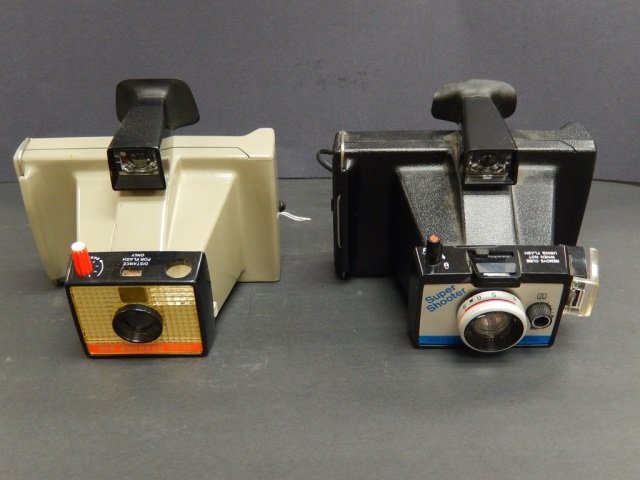 2 VINTAGE POLAROID CAMERAS: LOT INCLUDES ONE "SUPER SHOOTER POLAROID LAND CAMERA" AND ONE "POLAROID LAND CAMERA, BIG SWINGER 3000." CAMERAS ARE IN GOOD CONDITION AND ARE EACH APPROX 7" X 5" X 6"