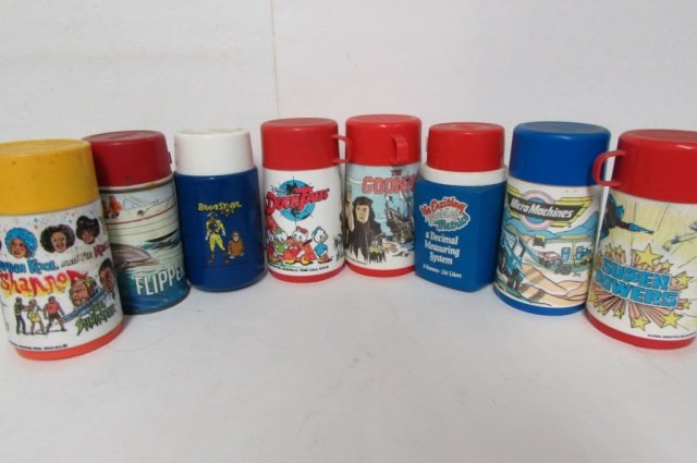 8 VINTAGE PLASTIC THERMOS BOTTLES: MICRO MACHINES, SUPER POWERS, THE KROFFT SUPERSHOW, DUCK TALES, THE EXCITING WORLD OF METRICS, FLIPPER, THE GOONIES, BRAVESTAR
