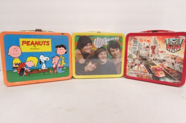 3 VINTAGE STEEL LUNCH BOXES THE MONKEES COLLECTIBLE TIN: THE MONKEES COLLECTIBLE TIN INCLUDES VIDEO AND JIGSAW PUZZLE, 1986 TRANS FORMERS LUNCH BOX INCLUDES THERMOS, & 1950S PEANUTS LUNCH BOX