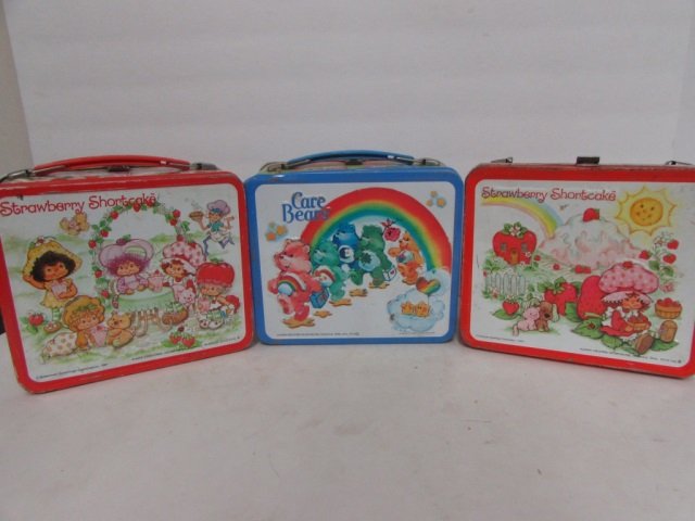 3 VINTAGE STEEL LUNCH BOXES (2) 1980 STRAWBERRY: (2) 1980 STRAWBERRY SHORTCAKE (ONE IS MISSING STRAP), CARE BEARS LUNCH BOX INCLUDES THERMOS, &