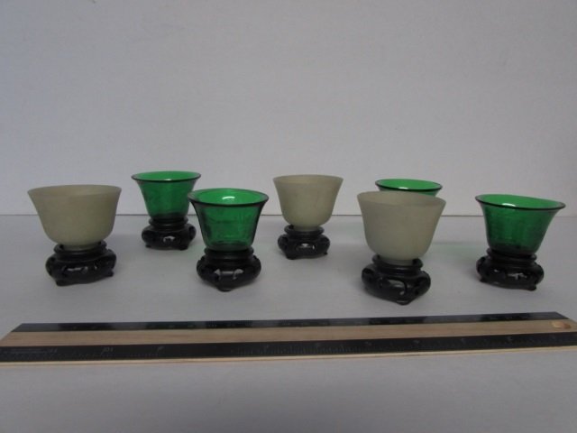 SAKE DRINKING SET THREE OPAQUE GLASS AND FOUR GREEN: THREE OPAQUE GLASS AND FOUR GREEN GLASS SAKE CUPS ON WOOD STANDS, 2.5" TALL