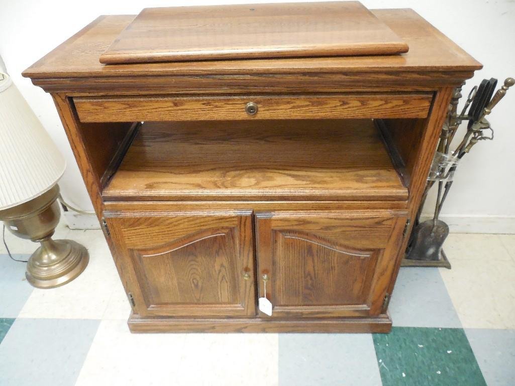 Wood TV Stand with Swivel Top: Wood TV stand with swivel top has drawer, pull out tray and cabinets. It is 35.5" tall and 34" wide. Good condition.