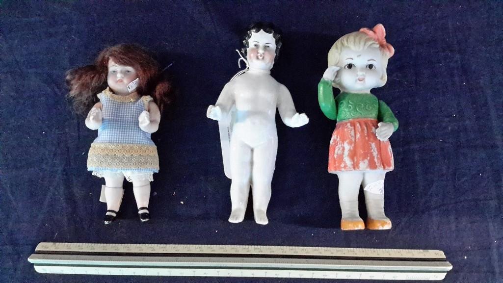 Bisque and Porcelain Dolls (3): Frozen Charlotte porcelain doll 6.5" tall, one bisque frozen Charlotte doll with painted clothes and face, moveable arms, 6.5", and one 5.5" bisque doll with moveable arms and legs