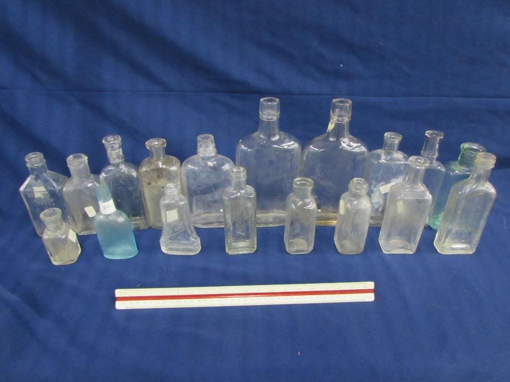 Assorted vintage glass bottles (18): One green glass bottle measures 6", one blue glass bottles measures 5", and (16) clear glass bottles, some are medicine bottles, sizes range from 3.5"- 8.5"