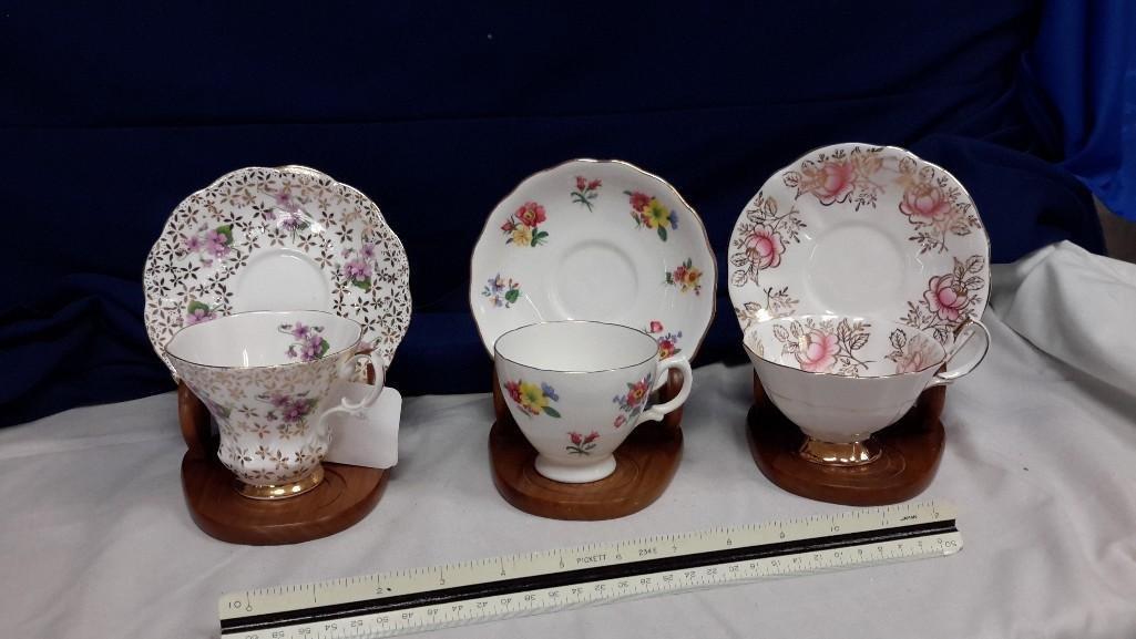 Bone China Tea Cups and Saucers (3 sets): One; Queen Anne, pink floral with gold detail.Second; Royal Vale, floral pattern. Third; Royal Albert, purple floral pattern with gold detail. 
