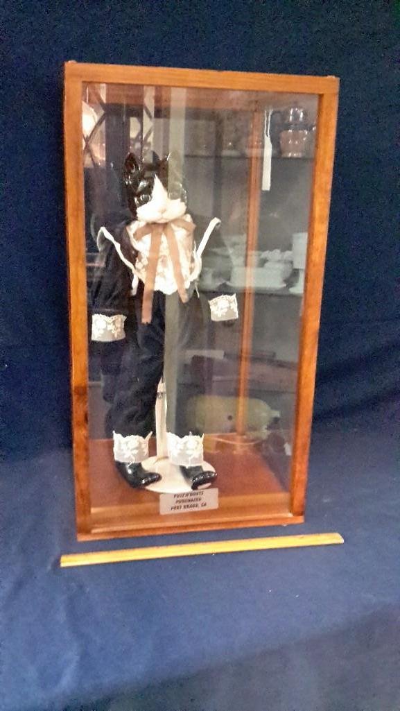 Puss N Boots Glass Cat Doll in Case: Plastic and wood case measuring 19" tall x 10 1/4" wide and deep. Cat approx. 16" tall. 