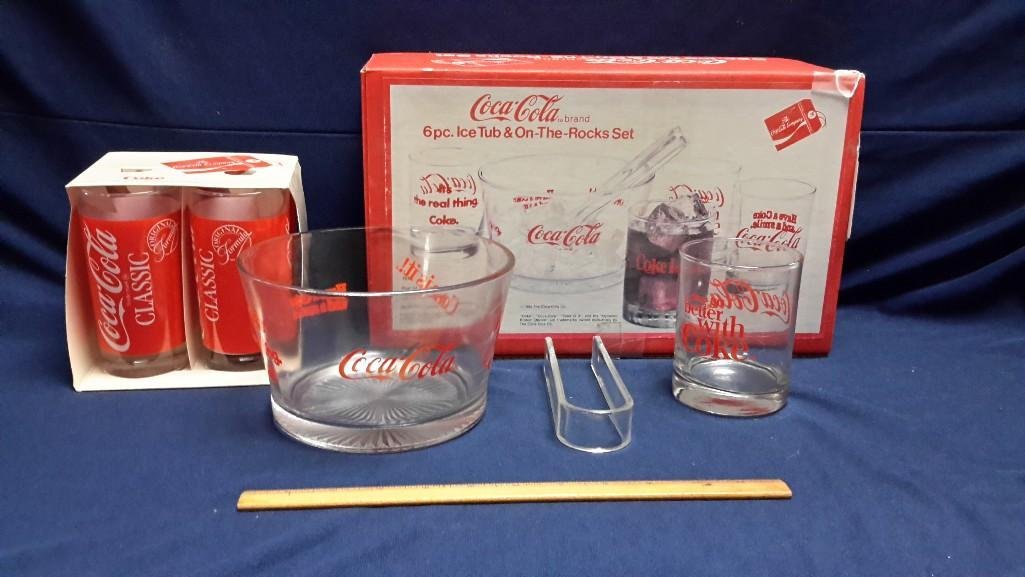 Coca-Cola Glass Ware Sets (2): 6pc Ice Tub and On the Rocks Coca-Cola Set which includes 4- 14 oz glasses, 1-55 oz ice tub and plastic tongs. Set of 4- 12 oz Coca-Cola beverage glasses. 