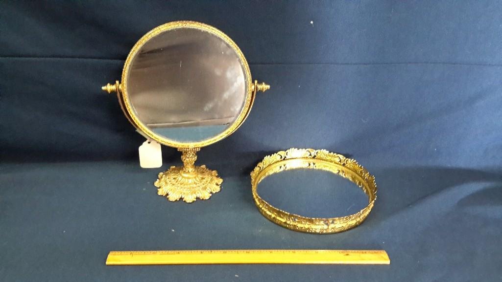 Decorative Mirrors (2): Gold toned beveled, swivel table mirror measuring 9" tall. Round gold toned mirrored tray measuring 6 1/2" diameter. 