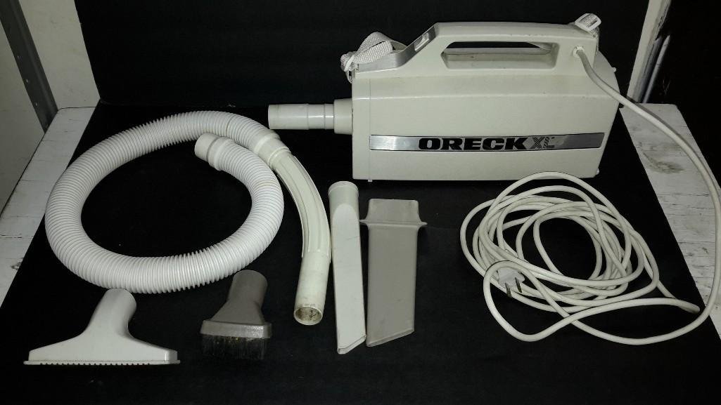 Oreck Handheld Vaccuum: model # BB-280D, with attachments. and a carrying strap.