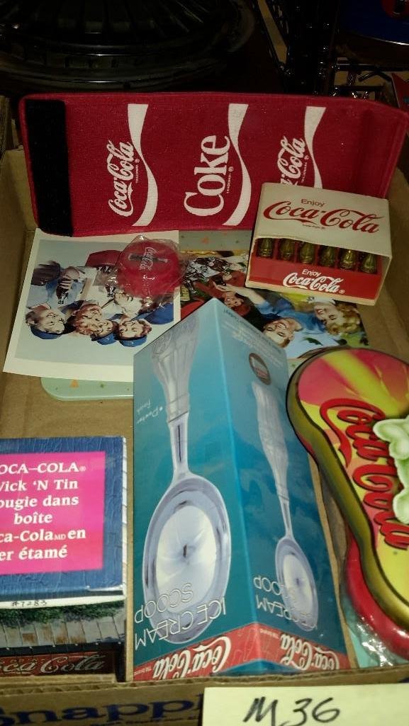 Small Coca- Cola Collectibles: Small plastic gold soda's, eye glasses, ice cream scoop, candle new in the box, and more.