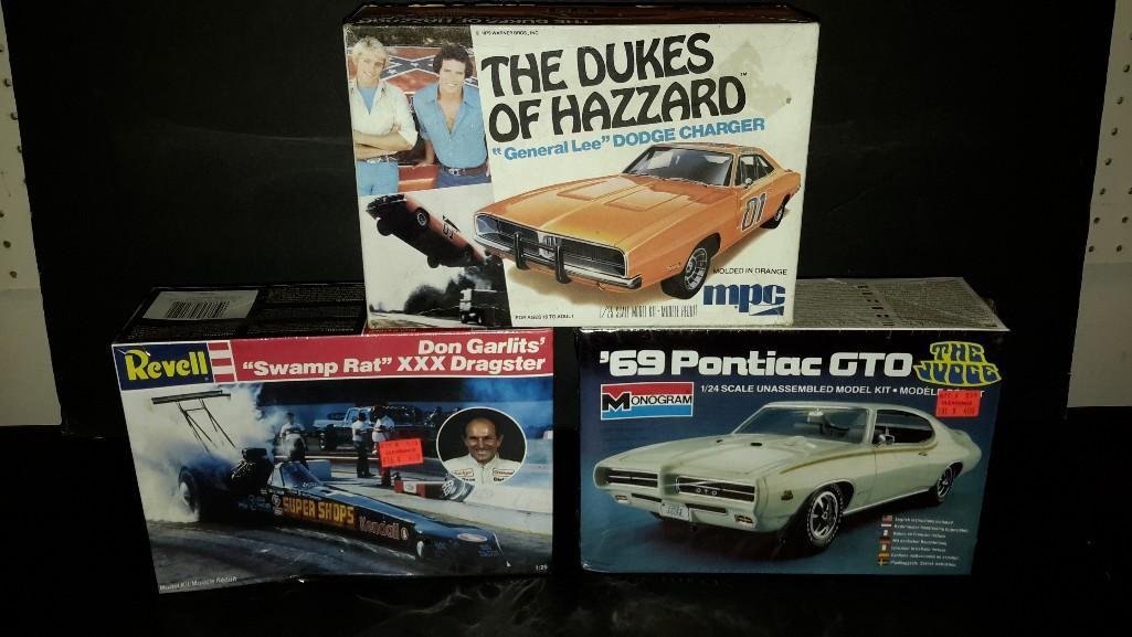 Model Kits (3): The Dukes of Hazzard General Lee Dodge Charger (box has been opened). Revell Don Garlits' Swamp Rat Triple X Dragster (in original wrapping), 69 Pontiac GTO (in original package). 