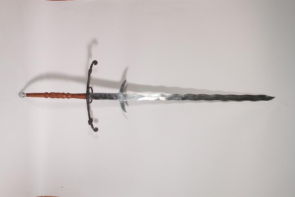 Reproduction Bastard Sword: Measures 64" long. Wood handle. Large ornate hand guard. 