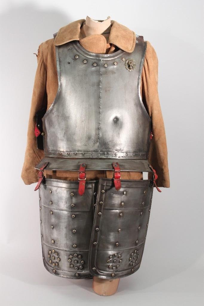 Reproduction Armor: Medieval armor, breast plate and leg guards, leg guards are hinged with leather straps, leather straps at shoulder and waist, lion medallion missing on right side, shows rust