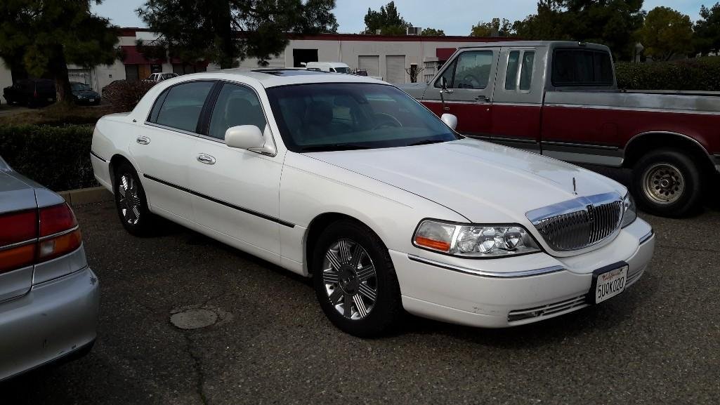 2003 Lincoln Town Car: mileage 105,229, Cartier Sedan four door, white. Vin # 1LNHM83463Y623369 Knob on lock door pops off, minor rear bumper damage, some small stains on carpet, small rid in front driver seat and sma