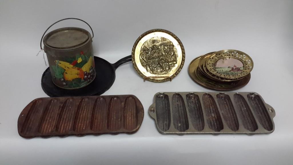 Cast Iron Ware & Metal Decor: Two Corn shaped cast iron molds, Solid brass wall hangings, one cast iron skillet, and a hand painted metal bucket 