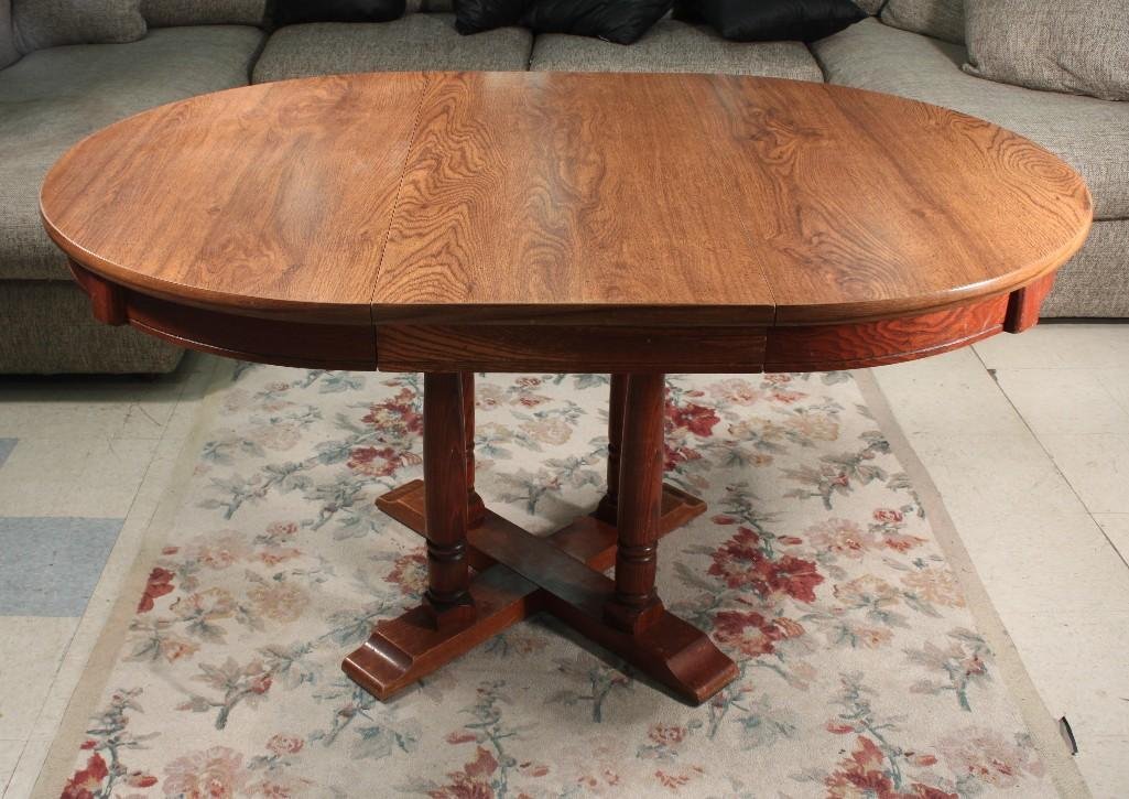 Round Oak Dining Table: 42" round table with one 18" leaf, in good condition, shows scuff marks at base of table, 1960's style