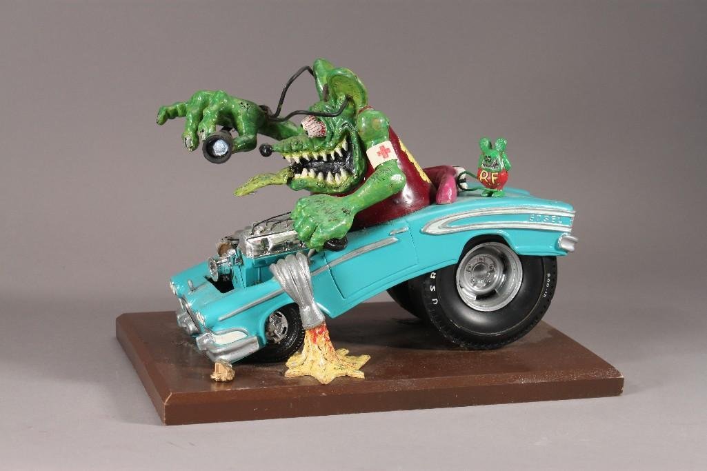 Stan "The Human Siren" Lemkuil Rat Fink Sculpture: Wood base measures 12" X 8". Sculpture is 8" tall, Fat Fink's vest reads "No Beauty All Beast Ed Roth", some chipped paint.