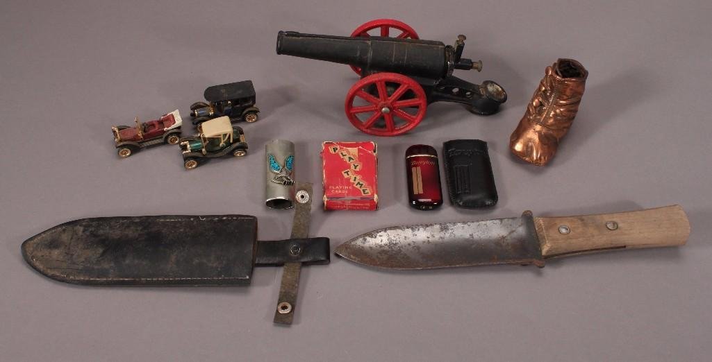 Men's Collectible Items: A 9 inch long cast iron cannon replica, a handmade knife with sheath, a copper baby shoe, cigarette lighter holder, mini deck of cards, vintage cars and more.