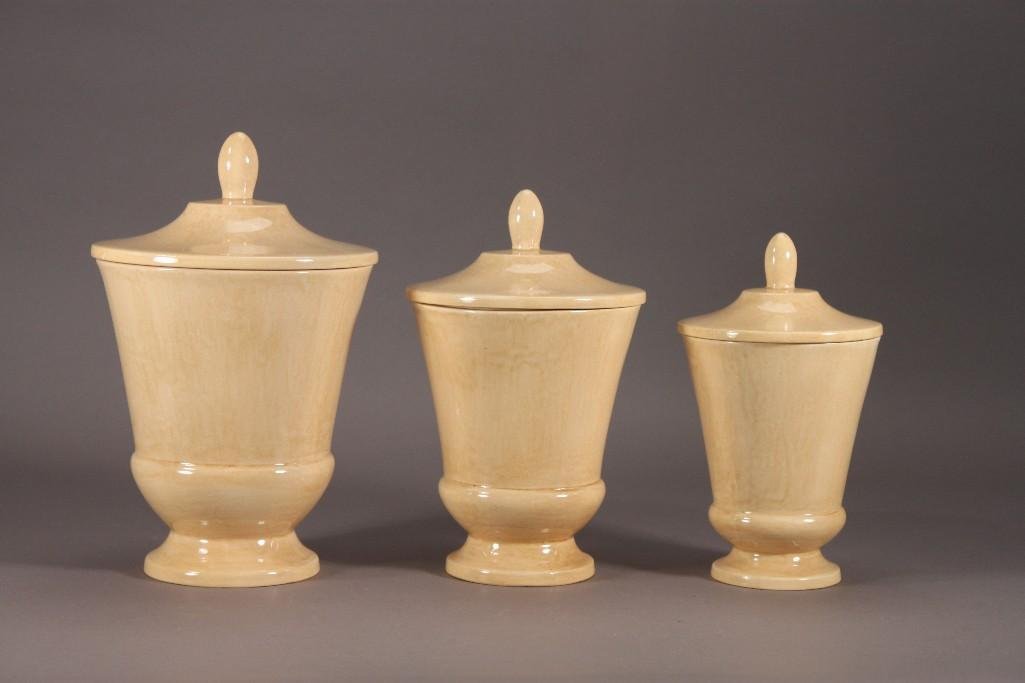 Canister Set (3): Beige urn style canisters measure 8", 9", 10" tall with lid.All in good condition.