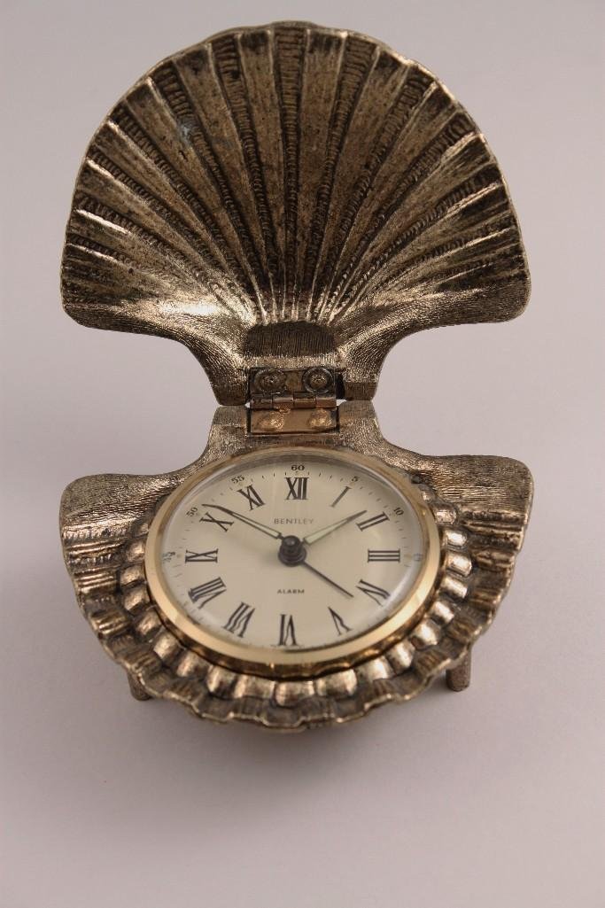 Bentley Alarm Clock: Clam shaped metal framed alarm clock measures 4" wide.