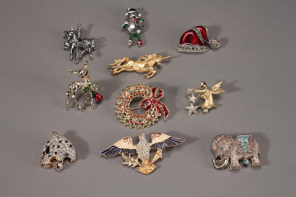 Brooches (10): Gold tone unicorn Trifari 2.5'' brooch, rhinestone gold tone eagle brooch marked Eisenberg Ice 3.25'' wide, Tancer holiday brooch, angel and star gold tone brooch marked Oiusti, snowman