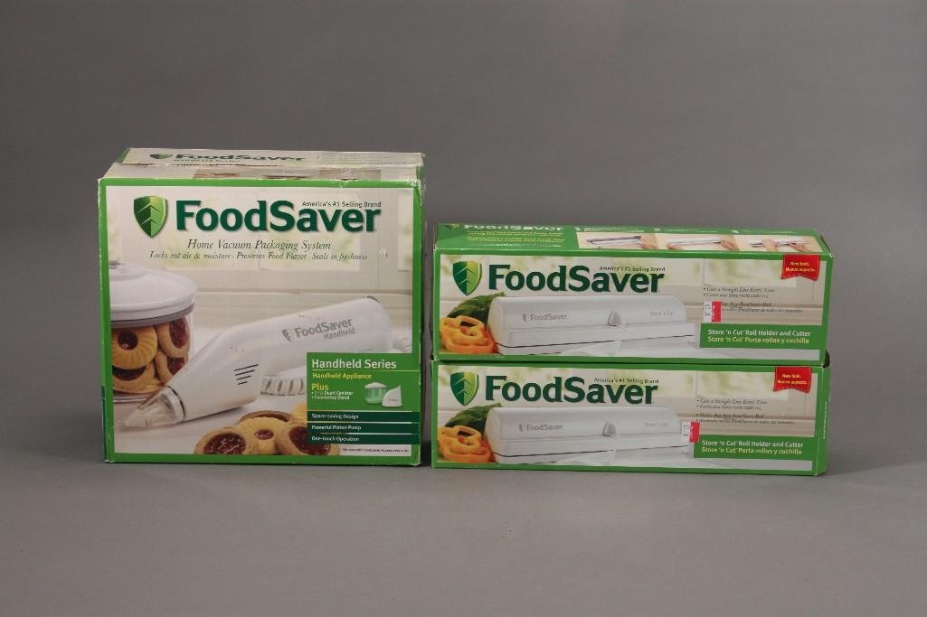 Food Saver System and Roll Cutters (3): Food Saver hame vacuum packaging system, handheld series and two Store N' Cut roll holder and cutter. All items are new in original packaging. 