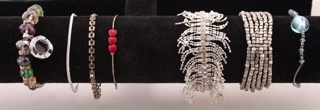 Silver Tone Bracelets (7): Silver tone chain bracelets, beaded bracelets, and rhinestone bracelets.