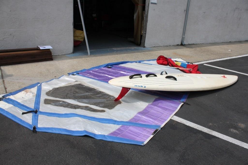 Mark 3 Wind Surf Board & Tri Sail: 10' 7" Mark 3 board is missing mast and fin is cracked. 15' x 7' Tri Sail with carrying bag.
