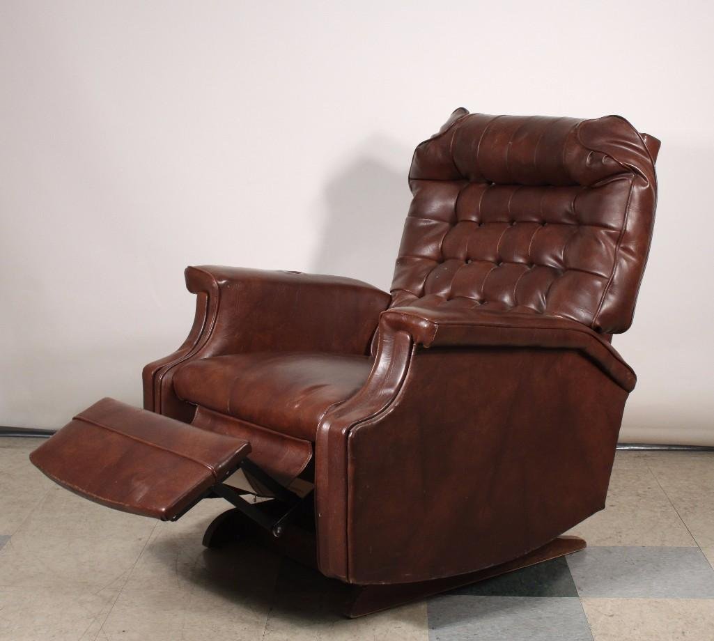 Brown Vinyl Rocking Recliner: Brown rocking recliner chair, shows signs of age and wear and has tiny hole on the front otherwise in good condition, measures 39'' tall.