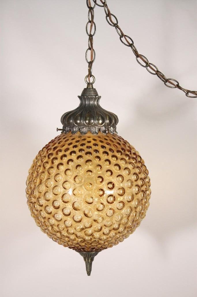 Mid Century Glass and Metal Hanging Light: Measures 15'' long, amber glass with a marble style globe design glass fixture, ornate metal top and bottom, has been tested and is in good working condition.