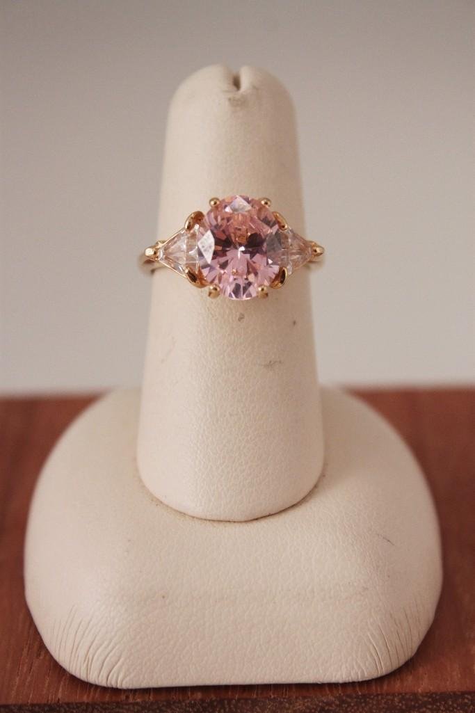 18 KT Gold Electroplate Ladies Ring: Bright pink oval stone with clear triangle shaped accent stones prong set on "18 KT G. E.", approx. size 5-6.