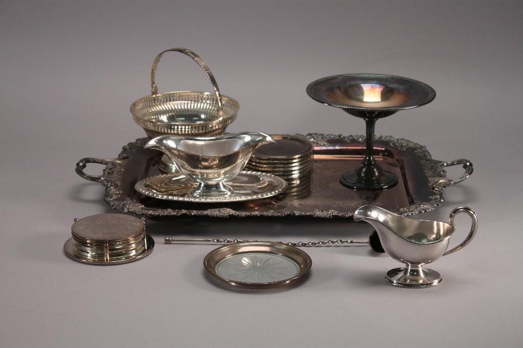 Footed Tray & Service Pieces (9): Silver plate coasters (2 sets), one silver plate and glass coaster, one silver plate candle snuffer, footedtray with handles measures 22" long, SP basket, Elkington & Co. creamer, compote, and silver