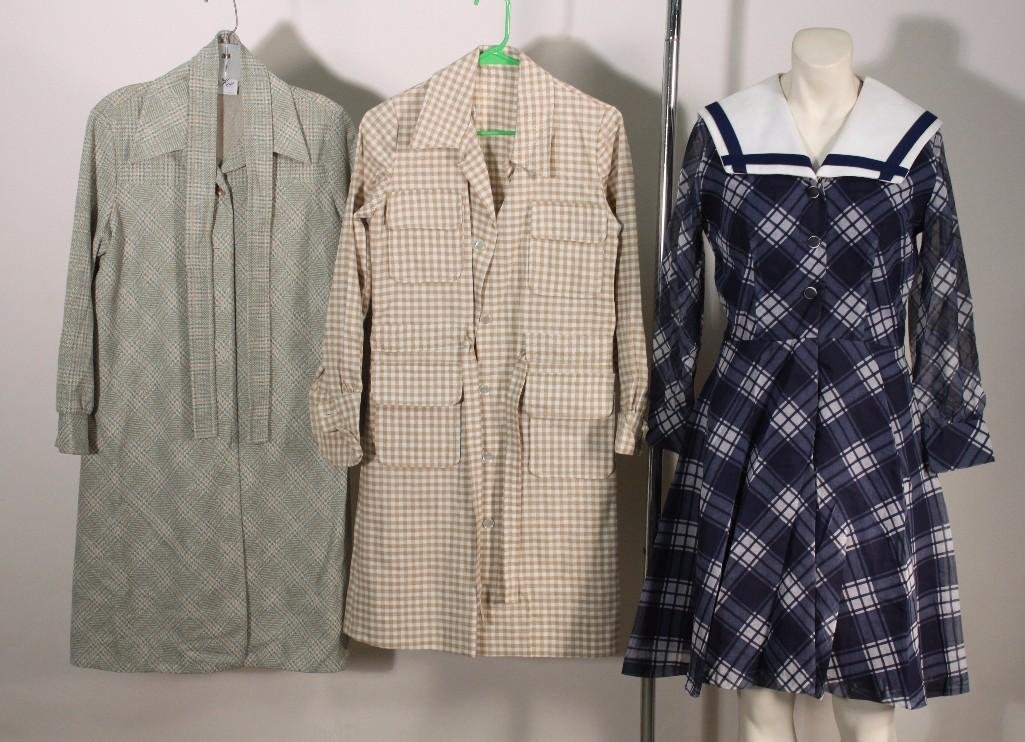 Ladies Vintage Clothing (3): Navy and white polyester dress size 12 designer not listed, white and brown checkered dress size and designer not listed (approx size ladies M/L), and a Butte Knit trench coat size not listed. Items a