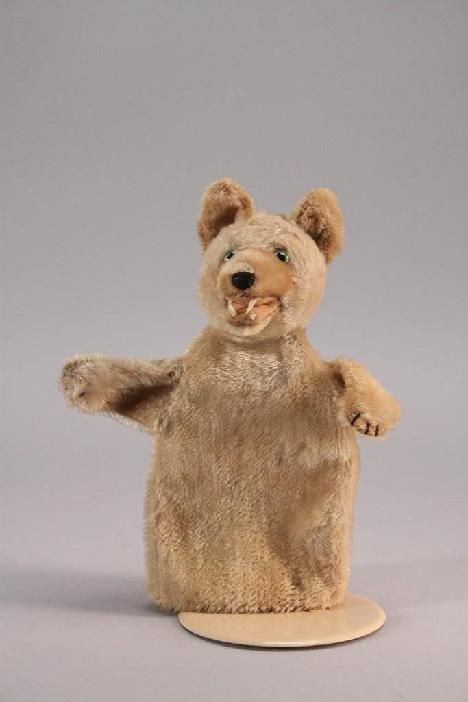 Steiff Wolf Puppet: 9" long tan colored mohair wolf puppet with green glass eyes, plastic teeth and stitched nose, good condition, no Steiff metal button or cloth label.