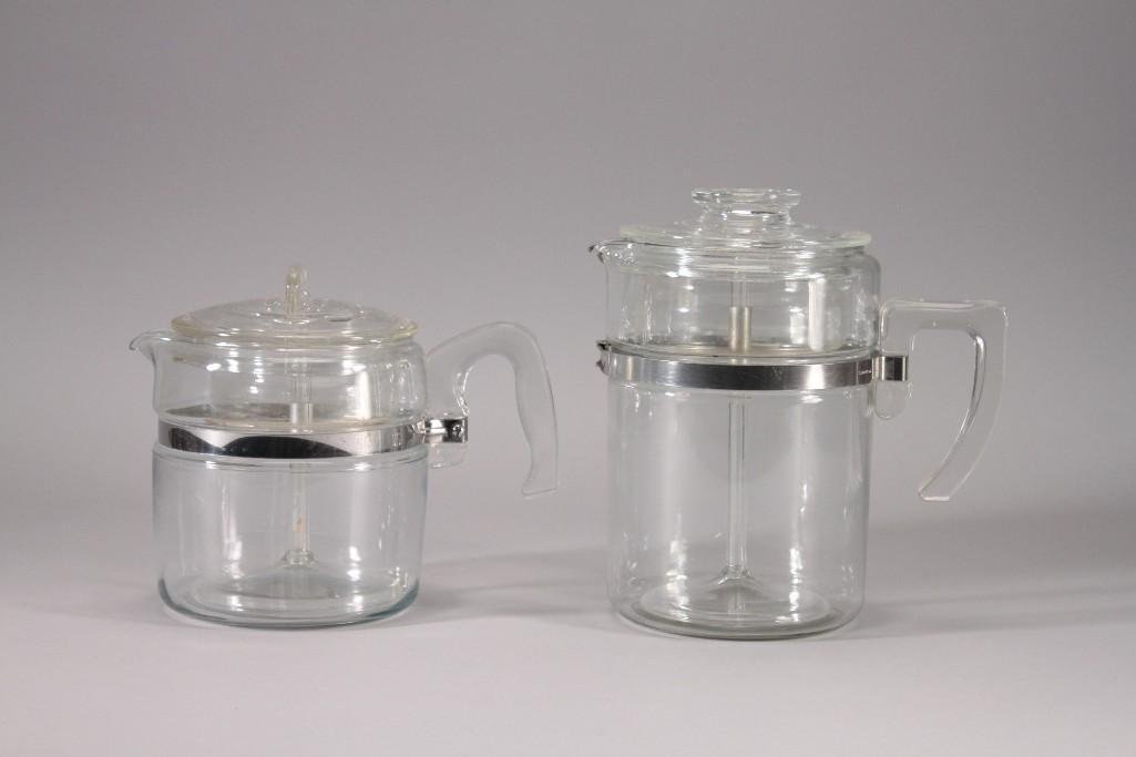 Pyrex Coffee Stove Top Percolators (2): One measures 7" tall and the other is 9" tall, marked Pyrex, stainless. Shows signs of use, no chips cracks or breaks, slight residue on baskets. Both are complete and in good pre-owned condition.